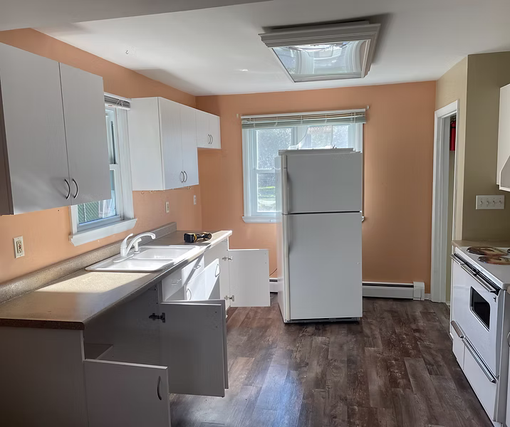 Kitchen with new vinyl plank flooring and fresh paint, ready for cabinet updates