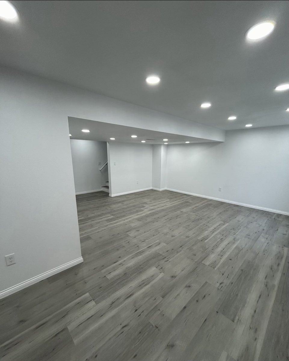 Finished lower level with gray luxury vinyl plank flooring and recessed lighting throughout